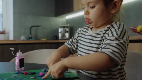 Édes Gyermek Lány Alkalmazása Különböző Részleteket Zöld Papíron Ragasztóval Miközben — Stock videók