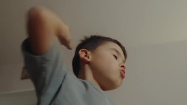 Elleri havada, el kol hareketi yapan ve yaratıcı oyunlar oynayan küçük çocuk. Oyun oyna.