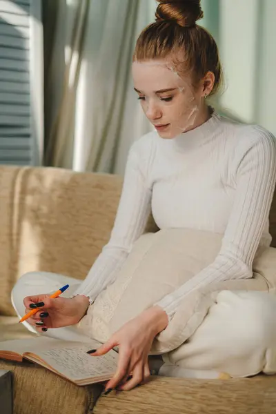 Donna Soddisfatta Indossando Maglione Bianco Seduto Sul Divano Scrivere Organizzatore — Foto Stock