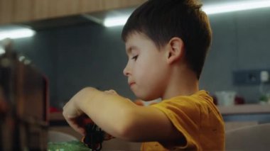 Tatlı çocuk ve kız araba oyuncakları ve yeşil parlak yapışkan sümükle oynuyorlar. Bebek için boş zaman aktivitesi, evlat. Duyusal ve yaratıcı becerilerin gelişimi.