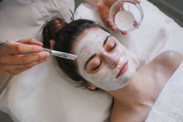 Woman getting professional skin care procedures at spa salon. Cosmetic facial treatment concept