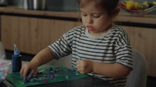 自家製のカードアートやグリーンペーパーに着色された綿のボールにこだわった工芸品を作る子供の少女 芸術と工芸の時間 — ストック動画