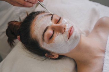 Kozmetikçiler kadın yüzüne krem maske takarak cilt tazeleme, güzellik salonlarında yaşlanma karşıtı kozmetik prosedürler uyguluyorlar..