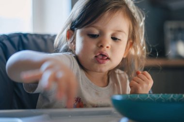Küçük kız kahvaltı yapıyor, pirinç lapası yiyor. Afiyet olsun..