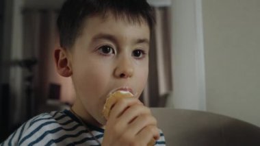 Kafkas çocuk neşeli ve duygusal olarak evde dili ile waffle bardağında dondurma yalıyor. Yakın plan..