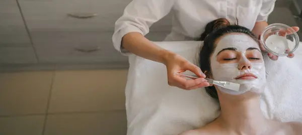 Beautiful Young Woman Receiving Ehite Facial Mask Beauty Salon Free Stock Image