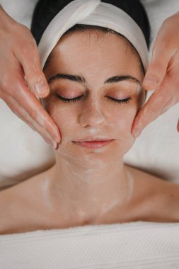 Nitelikli bir kozmetolojistin, müşterileri maske uygulamasına hazırlayan yakın plan görüntüsü. Güzellik prosedürleri kavramı. Güzellik salonu. Yüz maskesi