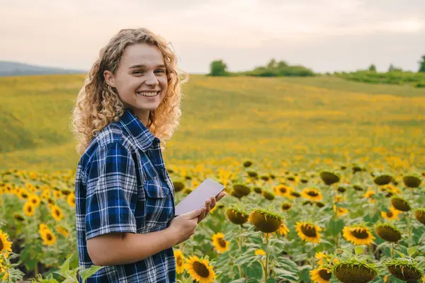 Молодая Кудрявая Женщина Фермер Рубашке Проверяет Состояние Урожая Планшете Подсолнечном Стоковая Картинка