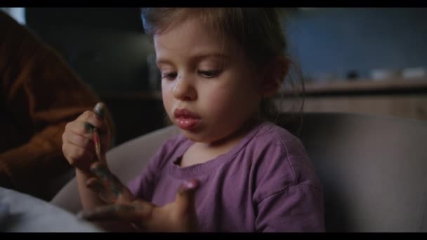 小女孩和奶奶坐在桌旁 用水彩画着她的手 用刷子刷着 敬爱的祖母 — 图库视频影像