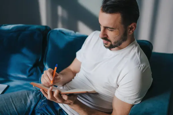 白人男性は日記で考えを書き留めている メモ帳でメモを作るクリエイティブマン ストックフォト