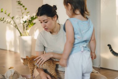 Aile tatili, anne, kız ve kızıl kedi hafta sonları oturma odasında dinleniyorlar..