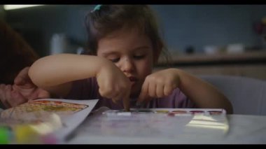 Genç bir kız sanatına, resim ve çizimlerine odaklanmış, yaratıcı bir neşe ve ifade anı yakalamış.
