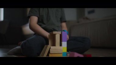 Bir çocuk renkli ahşap bloklarla oynuyor, el işi öğreniyor ve yaratıcı oyunlar oynuyor.