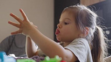 Bir çocuk eğlenceli bir şekilde renkli oyuncaklara bağlanır, oyun sırasında hayal gücünü ve yaratıcılığını gösterir..