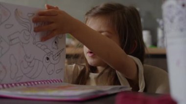 Genç bir çocuk canlı bir kitapla neşe içinde yaratıcılıklarını ve hayal güçlerini canlı renklerle sergiliyor.