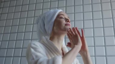 Cilt bakımı gibi sakin ve sakin bir an şık bir banyo ortamında gerçekleşir.
