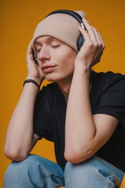 Bereli genç bir adam kendini müziğe kaptırır, düşüncelere dalmış, canlı renklere karşı titreşimler yayar.