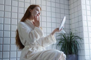 Şık ve şık bir banyo ortamında, rahat bir bornoz giyen bir kadının kendi bakım rutinini düşünmesi zaman alır.