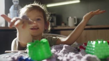 Neşeli bir çocuk neşeli bir şekilde çeşitli renkli oyuncaklarla meşgul, yaratıcılığını ve mutluluğunu gösteriyor.