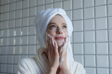 Bu sakin sahnede, bir kadın yüzünü yıkıyor, kendini düşünmenin ve rahatlamanın önemini gösteriyor.