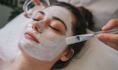 Bir kadın dingin bir spa ortamında dinlenirken canlandırıcı ve rahatlatıcı bir yüz tedavisiyle eğleniyor.