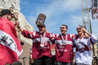 RIGA, LATVIA. 29 Mayıs 2023. Rihards Bukarts (L), Miks Indrasis, (C) IIHF Worlds 2023 Letonya Buz Hokeyi Takımı Bronz Madalyası sahibi ve Renars Kaupers (R), Brainstorm grubu. Özgürlük Anıtı 'na büyük bir kutlama var..