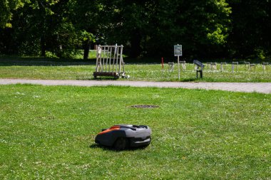 TÜKÜM, LATVIA. 17 Temmuz 2023. Seçici odak fotoğrafı. Husqvarna robot çim biçme makinesi.