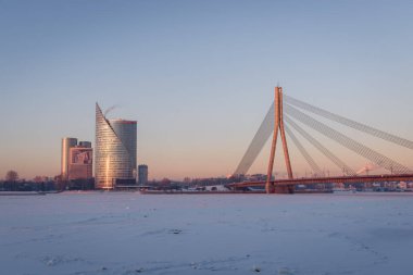 RIGA, LATVIA. 8 Ocak 2024. Seçici odak fotoğrafı. Riga şehrinin üzerinde gün doğumu. Buzlu kutup soğuğu Riga şehrinde -21 derece sıcaklık getirirken, -28 derece Riga Uluslararası Havaalanı 'ndaydı..
