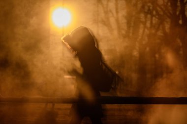 RIGA, LATVIA. 8 Ocak 2024. Seçici odak fotoğrafı. İnsan kaldırımda yürür. Riga şehrinin üzerinde gün doğumu. Buzlu kutup soğuğu Riga şehrinde -21 derece sıcaklık getirirken, -28 derece Riga Uluslararası Havaalanı 'ndaydı..