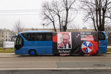 RIGA, LATVIA. 15 Mart 2024. Vladimir Putin 'in bayrağı, Rusya Başkanı Riga' daki Rusya Büyükelçiliği önünde otobüste..