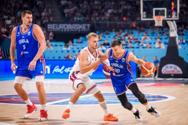 RIGA, LATVIA. 30 Ağustos 2025. Nikola Jokiç (L), Arturs Zagars (C) ve Aleksa Avramoviç (R), FIBA EUROBASKET 2025 basketbol karşılaşmasında milli takım Letonya ve Sırbistan milli takımı arasında oynanan karşılaşmada.