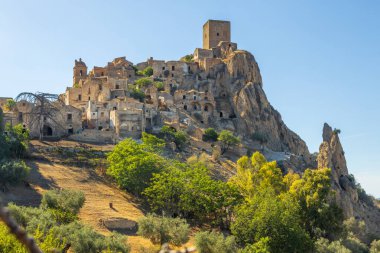 Kum taşından yapılmış terk edilmiş, eski bir dağ kasabası olan Craco 'nun pitoresk bir manzarası. Craco, 20. yüzyılın sonlarında meydana gelen deprem yüzünden terk edilmiş bir hayalet kasaba. Matera ili, Basilicata, İtalya