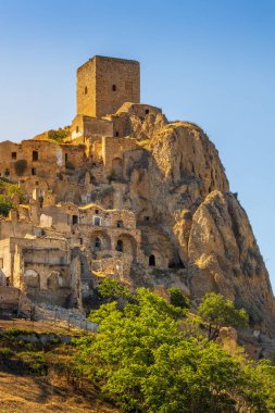 Kum taşından yapılmış terk edilmiş, eski bir dağ kasabası olan Craco 'nun pitoresk bir manzarası. Craco, 20. yüzyılın sonlarında meydana gelen deprem yüzünden terk edilmiş bir hayalet kasaba. Matera ili, Basilicata, İtalya