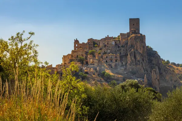 Kum taşından yapılmış terk edilmiş, eski bir dağ kasabası olan Craco 'nun pitoresk bir manzarası. Craco, 20. yüzyılın sonlarında meydana gelen deprem yüzünden terk edilmiş bir hayalet kasaba. Matera ili, Basilicata, İtalya