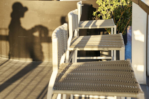 Shadow of a woman and empty chairs