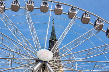 View of the ferris wheel and the bell tower of the Nikolaikirche; Villach, Austria