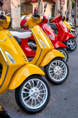Sarı ve kırmızı Vespalar Roma, İtalya 'da park halindeler.