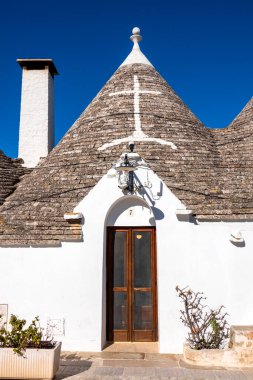 Trullo, Alberobello, İtalya 'nın yenilenmiş taş çatısında beyazlatılmış semboller.