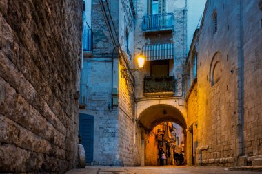 Piazza 62 Marinai, Bari, İtalya 'da akşam sahnesi, karakteristik dar sokakları ve tarihi taş binalarıyla. Meydana, Aziz Niklas 'ın emanetlerini Myra' dan Bari 'ye taşıyan 62 denizcinin adı verildi..