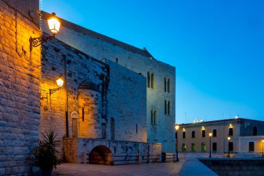 İtalya 'nın Bari kentindeki Via Venezia' nın karanlık manzarasında, eski şehrin ortaçağ duvarları boyunca Bazilika di San Nicola 'nın arkası görülüyor..