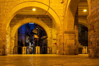 Largo Ignazio Chiurlia, Bari Vecchia, Bari, İtalya 'nın aydınlık taş kemerlerinin gece görüşü.