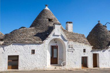 Alberobello, İtalya 'da Via Verdi' de konik çatısı olan klasik bir beyaz taş trullo. UNESCO Dünya Mirası Bölgesi..