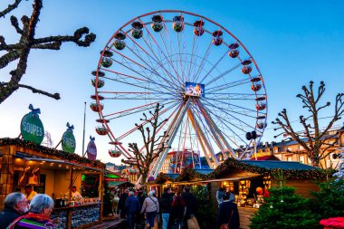 Lüksemburg 'un Wantermaart (Kış Pazarı) şehrindeki neşeli dönme dolap, şenlik tezgahları ve ziyaretçilerle çevrilidir..