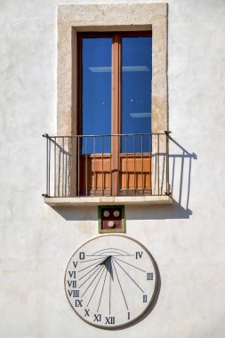 İtalya, Monopoli, Piazza Garibaldi 'deki tarihi güneş saati, belediye kütüphanesinin bulunduğu Palazzo Rendella' nın girişinin solunda yer almaktadır..