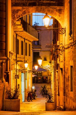 Bari Vecchia, Bari, İtalya 'da gece sokak lambalarıyla aydınlatılmış Piazza Mercantile yakınlarındaki sokak.