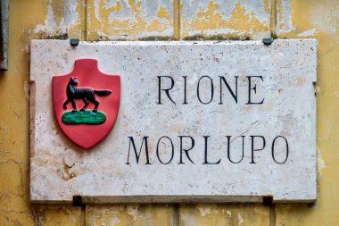  İtalya, Umbria, Foligno 'daki Rione Morlupo' nun mermer plaketinde pembe arka planda siyah bir kurt yer alıyor.. 