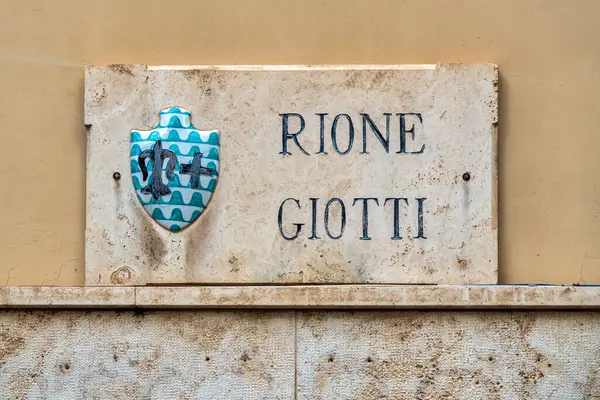 İtalya 'nın Foligno kentindeki Rione Giotti' nin mermer plaketi, bölgenin tarihsel önemini yansıtan Giotti ailesinin soyunu temsil ediyor.. 