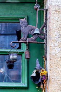 Lüksemburg 'da yeşil bir kapı girişinde yerel gelenekleri çağrıştıran folklorik cadı ve kedi kapısı süslemesi.