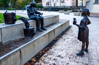 Genç bir su taşıyıcısının bronz heykeli ve güller sunan bir kız Spidolsgaart, Pfaffenthal, Lüksemburg, Lüksemburg 'da bulunuyor..