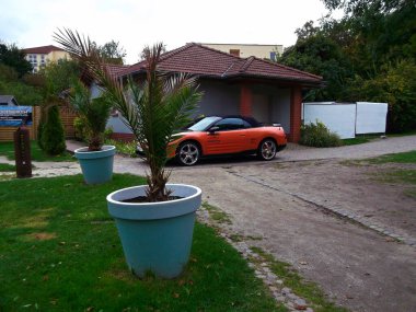 Templin, Brandenburg district of Uckermark / Germany - October 6, 2024: Mitsubishi Eclipse Cabrio in orange and advertising inscription Magnaflow clipart